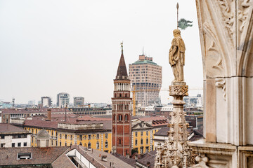 Fototapeta na wymiar Statue with a flag on the spire of the Duomo. Italy, Milan