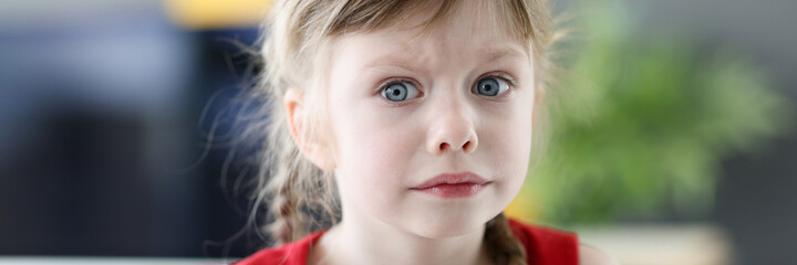 Portrait of little emotional girl with pensively frightened look closeup