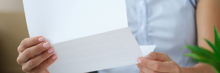 Woman holding envelope with paper letter or invitation inside