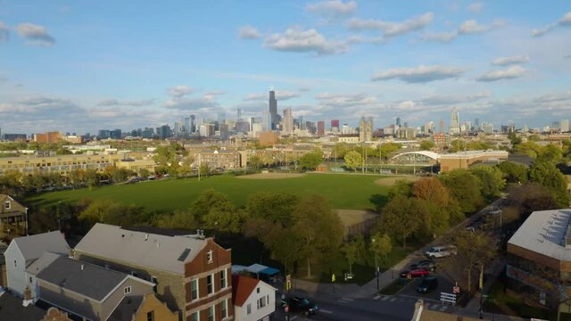 Low Aerial Establishing Shot of Harrison Park in Pilsen, Chicago. Skyline in Background