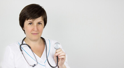 Doctor with a stethoscope in the hand. Medical doctor or physician in white gown uniform with stethoscope