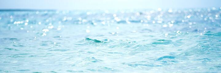 Abstract and blurred ocean or sea water with defocused bright sun light.Banner 