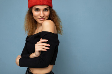 Photo of beautiful self-confident sexy young brunette curly woman isolated over blue background...