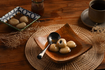 Sweet rice dumplings with sweet ginger soup served in a wooden plate.