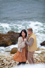 beautiful couple in love walks along the coast of the winter sea