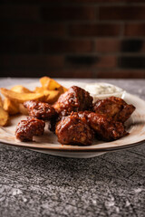selective focus. barbecue chicken wings in breaded and sweet sauce. with natural sauce. restaurant serving. on a dark background. for menus and ads