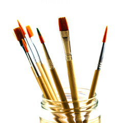 brushes for drawing of various diameters in a glass jar on a white background