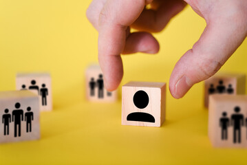 The search for new managers to lead organizations and teams is shown using wooden cubes, on a yellow background.