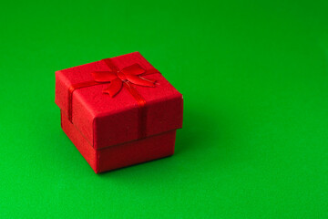 red gift box on a green background with copyspace
