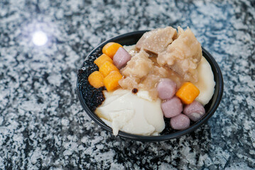 Taiwanese shaved ice with toppings. A Bowl of shaved ice with brown sugar syrup, topped with...