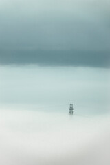 Electricity pylon with a power line in mist and pastel colored sky. The minimal concept with copy space. rural landscape