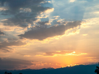 Beautiful sunset in the mountains. Landscape with sun shining through orange clouds, Sun setting over hills,  sunset on mountains