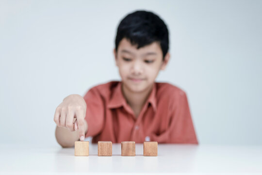 Asian Boy Choosing Wooden Cubes, Educational Concepts, And Learning In A New Normal.