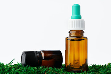 Bottle of aromatic oil for herbal medicine among natural green moss