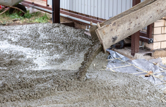 The machine is pouring concrete mix at a construction site.
