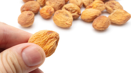 Dried apricot in hand on a white background.