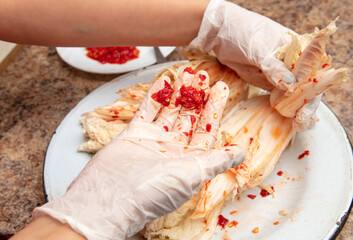A woman is salting cabbage in Korean in the kitchen.