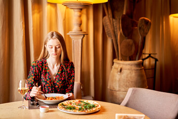 Woman eats Italian pasta with tomato, meat. Close-up spaghetti Bolognese wind it around a fork with...