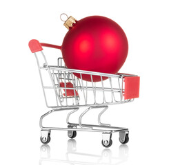 Concept of New Year's bustle and shopping. Christmas red ball in shopping cart isolated on white