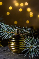 Golden Christmas ball on the Christmas tree. Selective focus. Bokeh background.