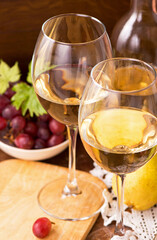Wine and grapes in vintage setting on wooden table.