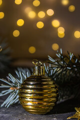 Golden Christmas ball on the Christmas tree. Selective focus. Bokeh background.