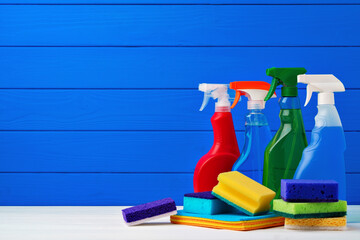 Various cleaning items against blue wooden background