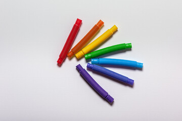 Set of rainbow colored new straight pop tubes on white paper background