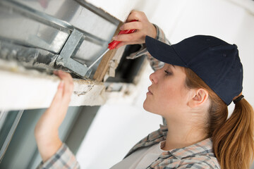 female worker adjusting stainless framework