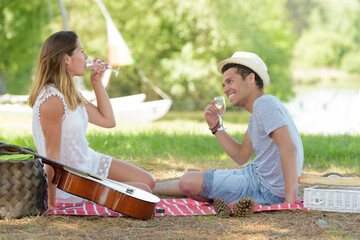 young couple on picnic drinking water