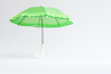 Green umbrella on a white background. Protection and safety concept
