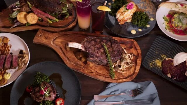 Top down view tabletop full of elegantly plated dinner options at an expensive romantic steakhouse, birdseye view slider HD