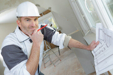 Portrait of builder holding property plans