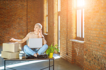 Happy female entrepreneur watching webinar and talking during meeting video conferences call with...