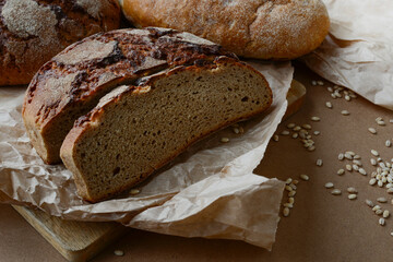 Sliced fresh bread on a wooden background. Baking bread. Natural rye bread made by hand in a home bakery from natural ingredients. Healthy food, delicious homemade bread