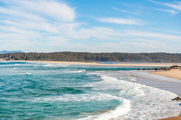 Ocean waves and sandy beach on a sunny day. Nature tropical paradise background. Tuross Head, NSW, Australia