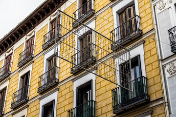 Old residential building against sky. Malasana quarter in Madrid. Real estate and architecture concepts. Christmas lights in the street