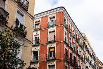 Fototapeta na wymiar Old residential building against sky. Malasana quarter in Madrid. Real estate and architecture concepts.