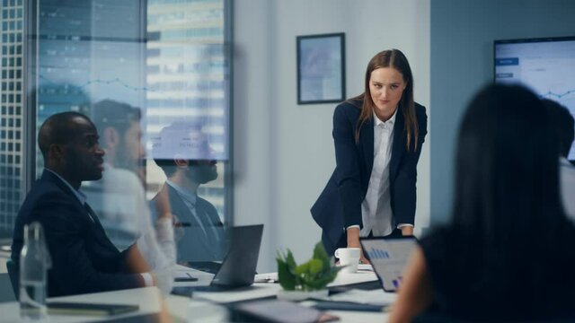 Diverse Office Conference Room Meeting: Motivated Female Digital Startup Owner Presents e-Commerce Fintech Growth Statistics to a Group of Investors. Wall TV with Big Data Analysis, Infographics