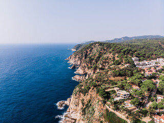 Drone view of rocky cliffs and the sea in the city of Tossa de Mar. Drone shot of a municipality in Spain. The resort town of Tossa de Mar near the Mediterranean Sea. Drone shot Tossa de Mar