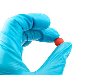 Hand doctor in medical blue gloves hold red pill.  Pill Research Concept.