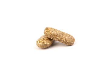 Nutrition supplements, brown vitamin pills on white background.