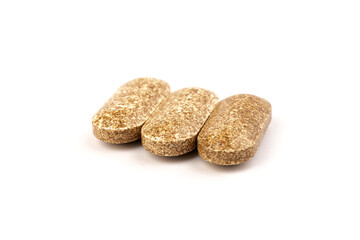 Nutrition supplements, brown vitamin pills on white background.