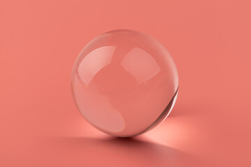 Crystal glass ball sphere transparent on pink background.