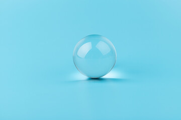 Crystal glass ball sphere transparent on blue background.
