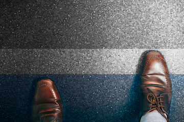 Top view of a businessman in a pair of shoes walking towards the finish line of success.
