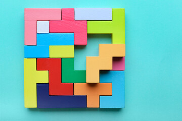 Multicolored puzzle, hand and cubes on a mint background - obrazy, fototapety, plakaty