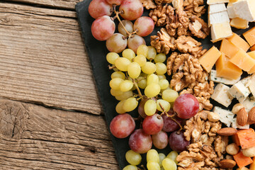 Cheese plate with variety of appetizers on table