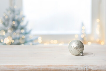 Xmas ball on table in front of defocused festive background