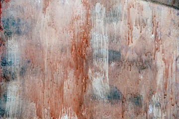 A very dirty wall splattered with red translucent paint. Abstraction on the wall background looks...